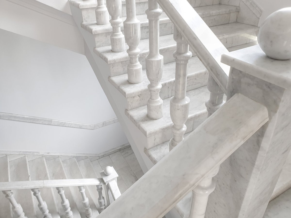 Elegant white marble staircase with a classic balustrade in an upscale suburban home