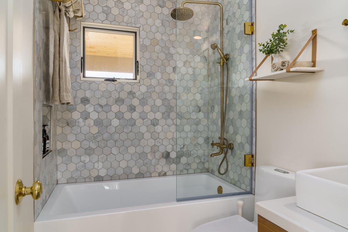 Modern white bathroom with tiled shower and hexagon tile