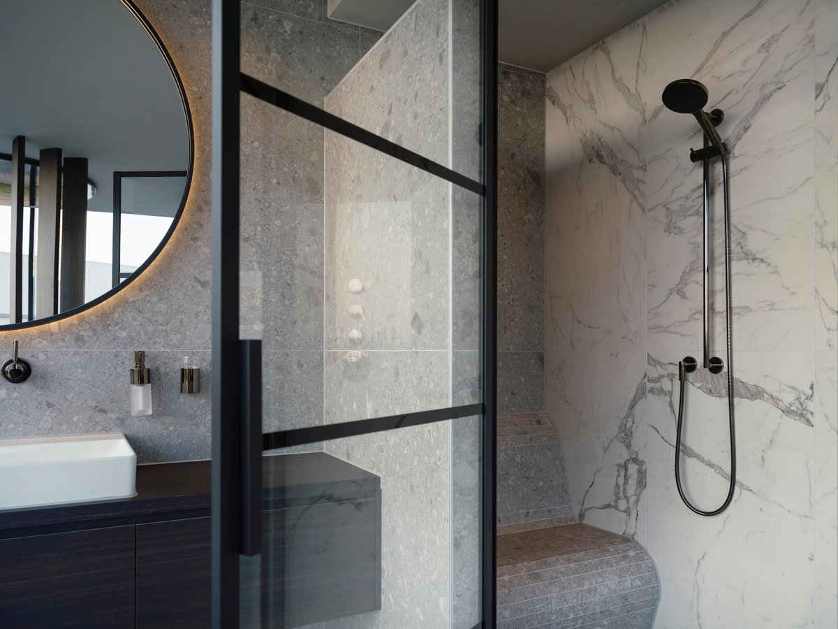 Luxury marble walk-in shower with glass enclosure and marble vanity